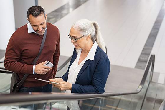 A senior looks at a digital table with her travel companion