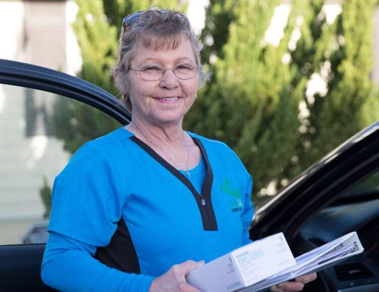 A FirstLight caregiver exits her car, on the way to visit a client